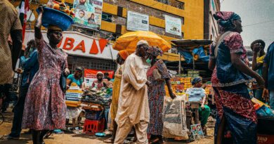 Traveler blending in with locals at a busy African street market, casual clothing, vibrant atmosphere, natural colors
