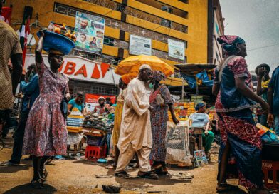 Traveler blending in with locals at a busy African street market, casual clothing, vibrant atmosphere, natural colors