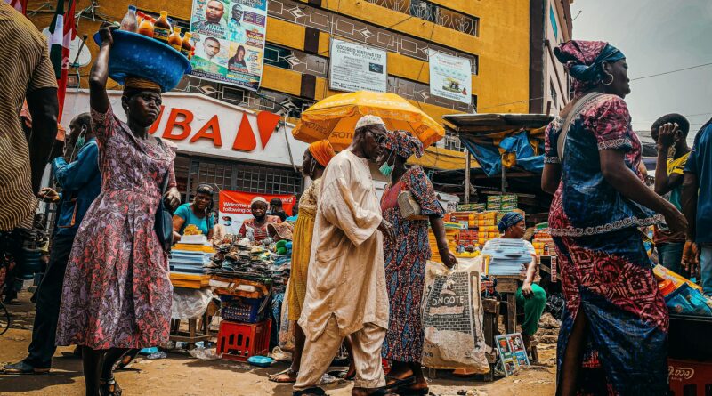 Traveler blending in with locals at a busy African street market, casual clothing, vibrant atmosphere, natural colors